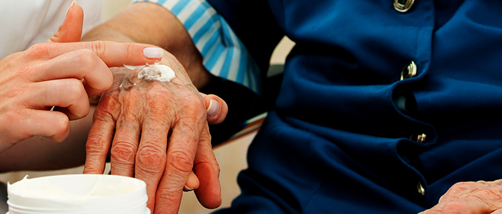 a person putting creme on another person's hand